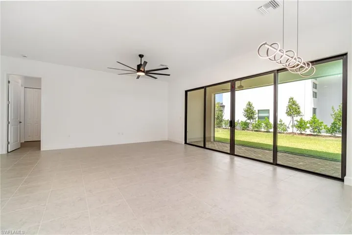 Unfurnished room with a ceiling fan and light tile patterned floors