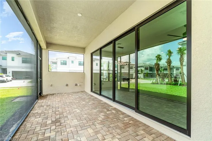 Unfurnished sunroom featuring a residential view, a ceiling fan, and a patio