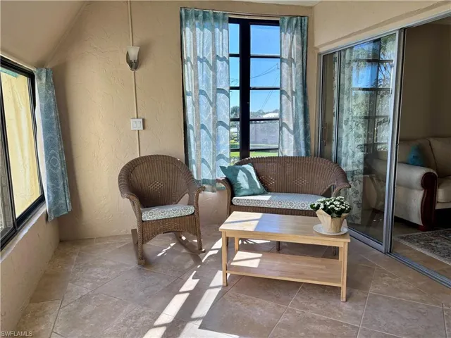 Sitting room featuring tile patterned floors, plenty of natural light, and lofted ceiling