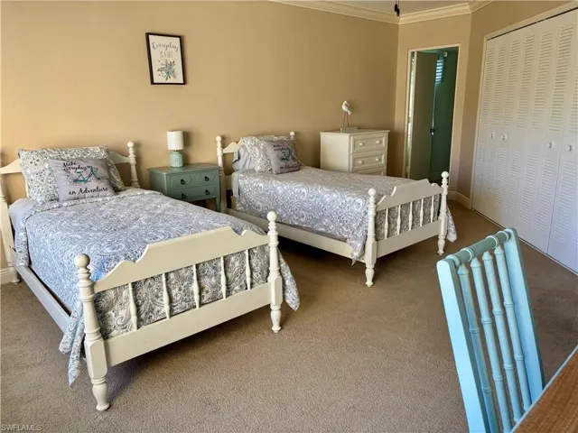 Bedroom with carpet flooring, a closet, and ornamental molding