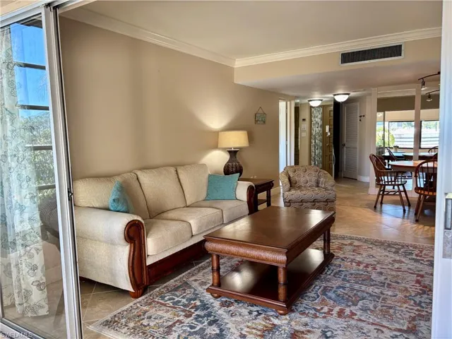 Living room with tile patterned floors and crown molding