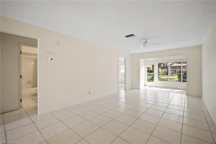 Spare room featuring ceiling fan, a textured ceiling, and light tile patterned floors