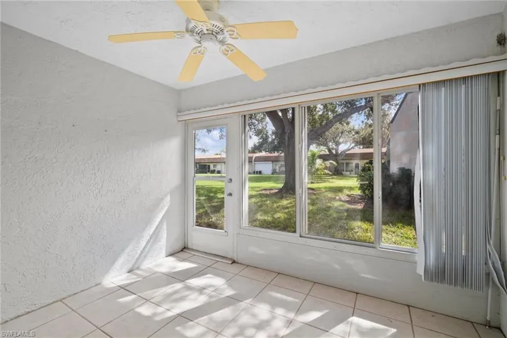 Unfurnished sunroom with ceiling fan