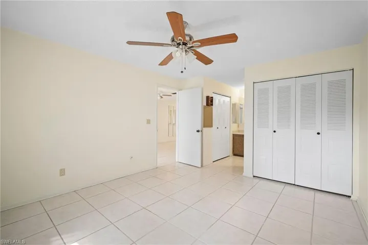 Unfurnished bedroom featuring light tile patterned floors and ceiling fan