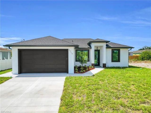 Prairie-style house with fence, a front yard, stucco siding, an attached garage, and driveway