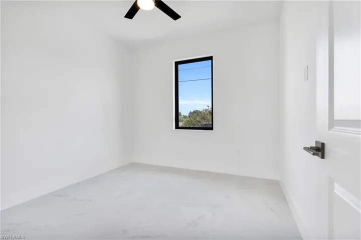 Spare room featuring baseboards, ceiling fan, and marble finish floor