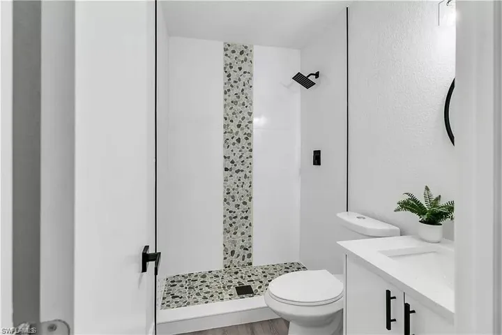 Full bathroom with vanity and a shower stall
