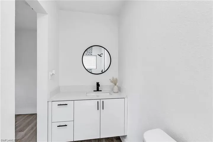 Half bath featuring vanity and wood finished floors