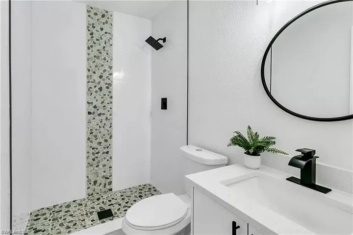 Full bathroom with vanity and a shower stall