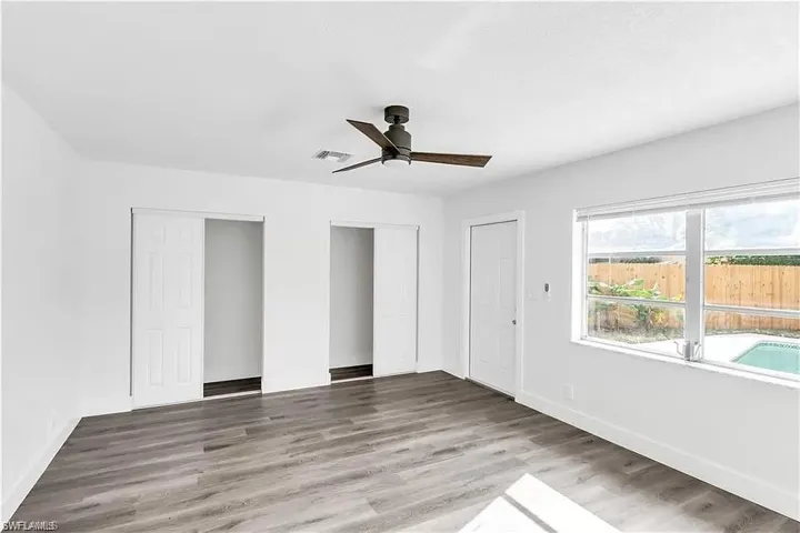 Unfurnished bedroom featuring two closets, light wood-type flooring, and a ceiling fan