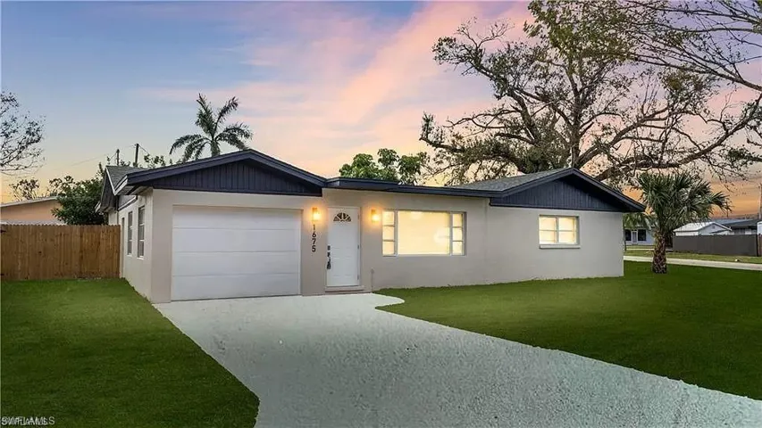 Single story home with concrete driveway, stucco siding, and a garage