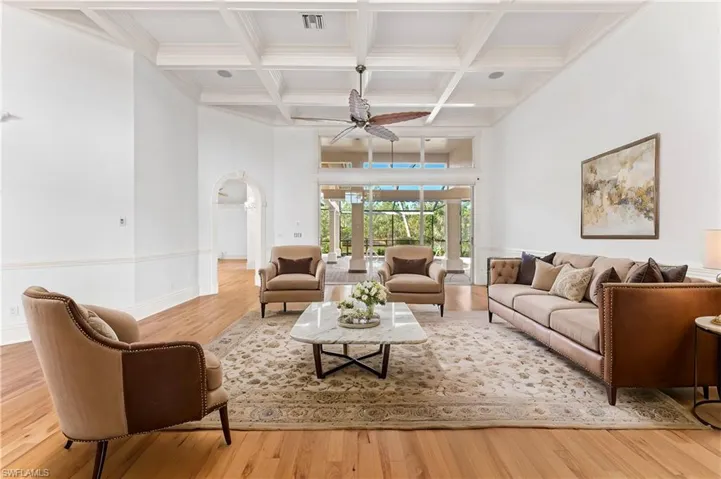 Living room with beam ceiling, light hardwood / wood-style flooring, ceiling fan, and coffered ceiling