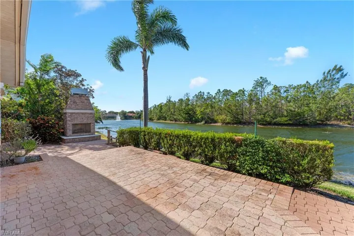 View of patio / terrace featuring an outdoor stone fireplace and a water view
