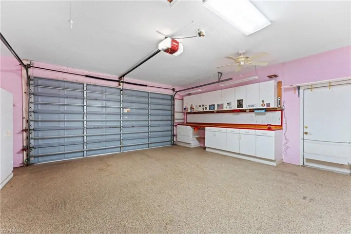 Garage featuring ceiling fan and a garage door opener