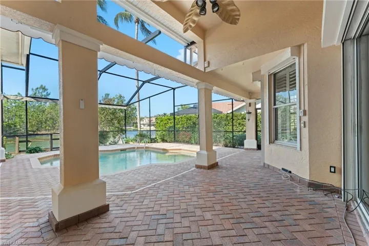 View of pool featuring a lanai, ceiling fan, and a patio