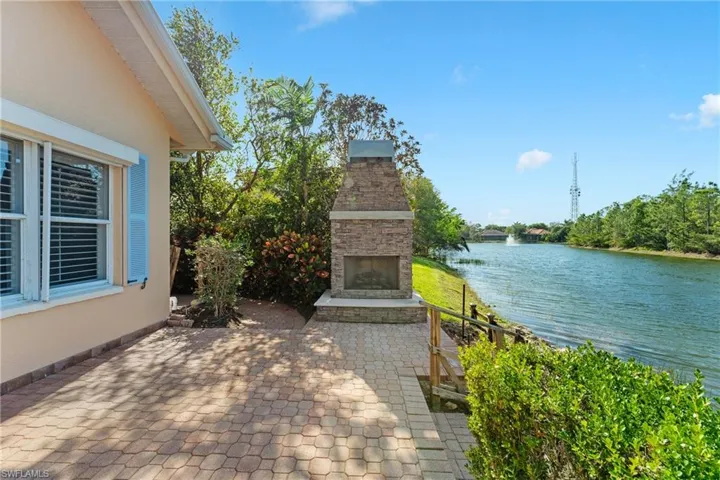 View of patio with an outdoor stone fireplace and a water view