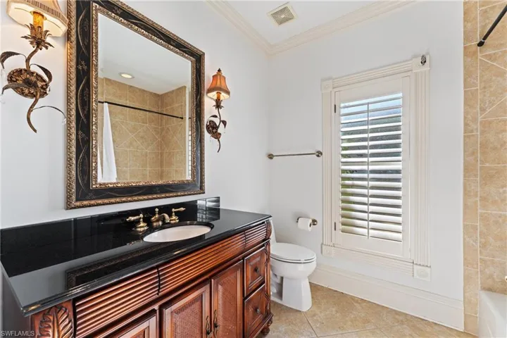 Full bathroom featuring vanity, tiled shower / bath, tile patterned flooring, toilet, and ornamental molding