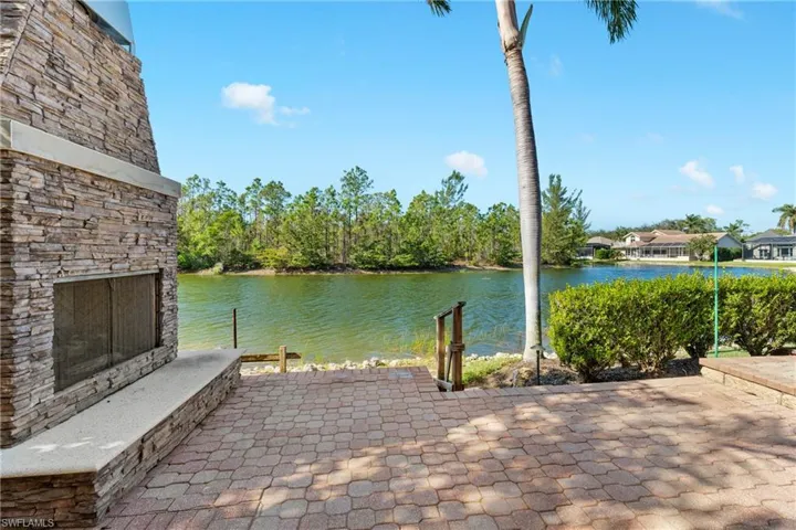 View of patio / terrace with a water view and an outdoor stone fireplace