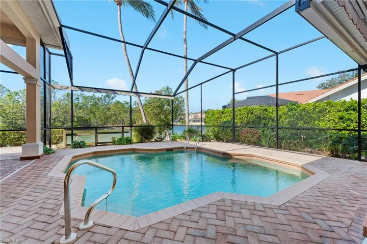 View of swimming pool with glass enclosure and a patio
