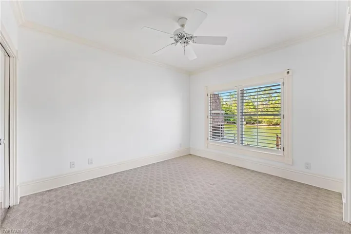 Carpeted empty room with ceiling fan and crown molding