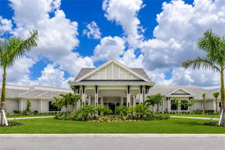 Symmetrical facade with covered entryway, gabled rooflines, and mature landscaping