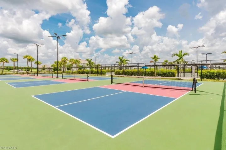 Multiple courts with colorful hard surfaces, complete with nets and perimeter fencing