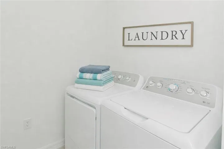 Laundry area with a white top-load washer and dryer