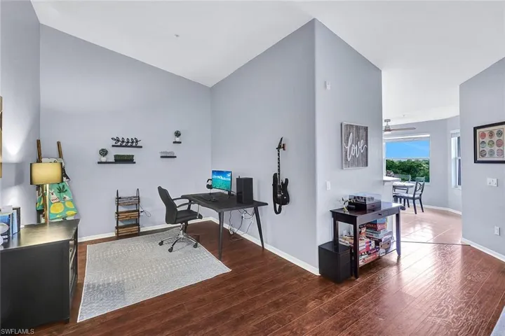 Office area featuring ceiling fan, lofted ceiling, and hardwood / wood-style floors