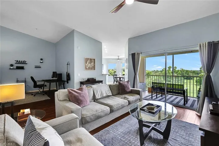 Living room featuring hardwood / wood-style flooring, ceiling fan, and high vaulted ceiling
