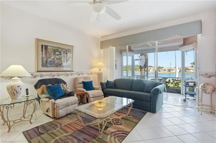 Tiled living area with ceiling fan and a water view