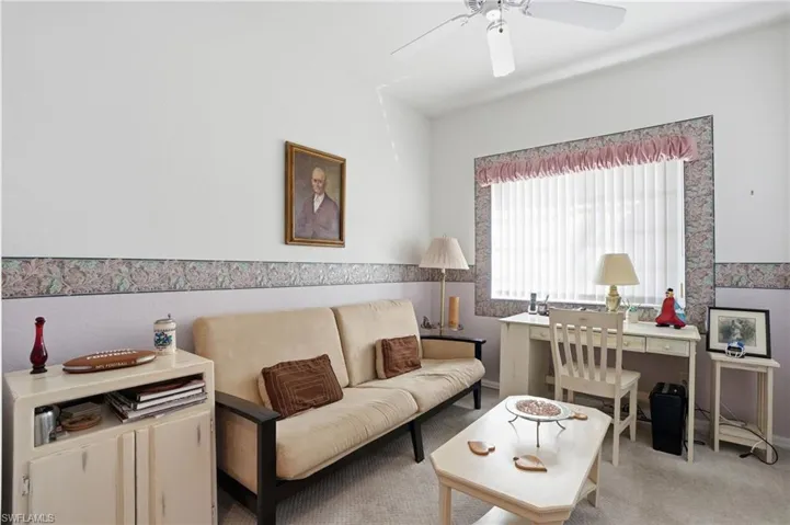 Carpeted living room with ceiling fan
