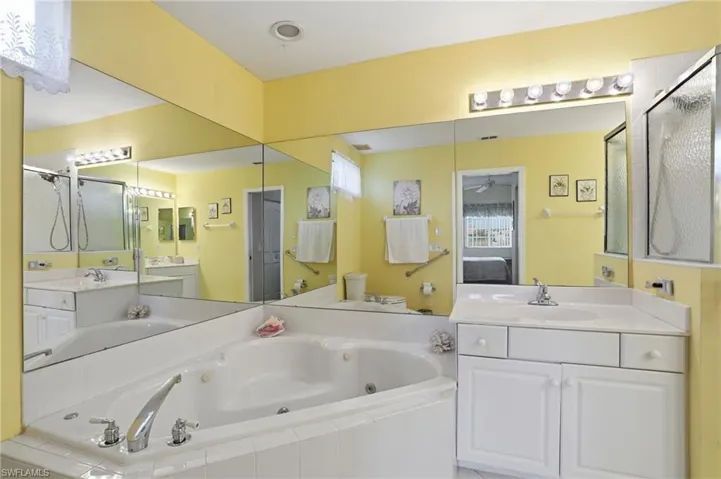 Ensuite bathroom with a jetted tub, a stall shower, and vanity