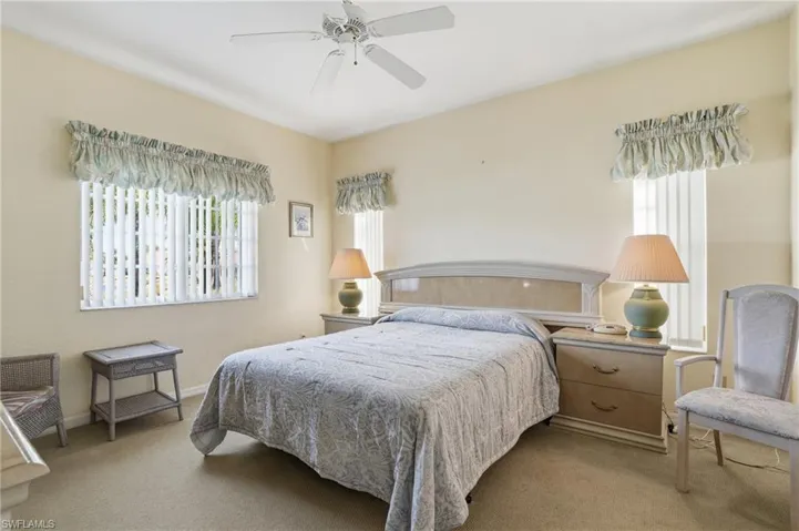 Carpeted bedroom featuring a ceiling fan and baseboards
