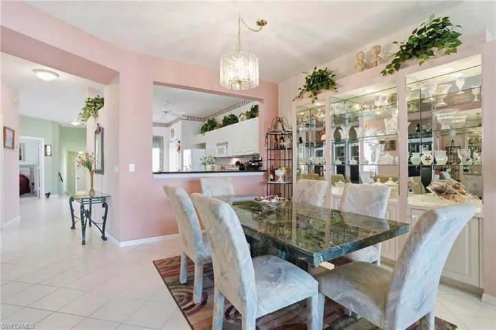 Dining room with ceiling fan, suspended lighting, and light tile patterned flooring