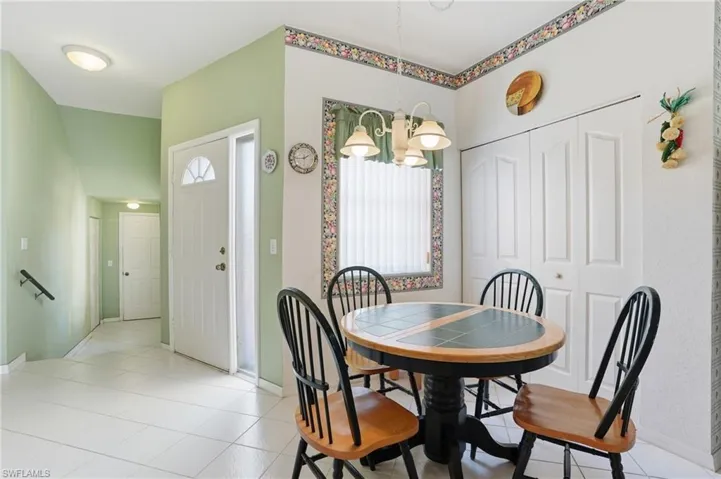 Dining area with light tile patterned floors, a chandelier, and plenty of natural light