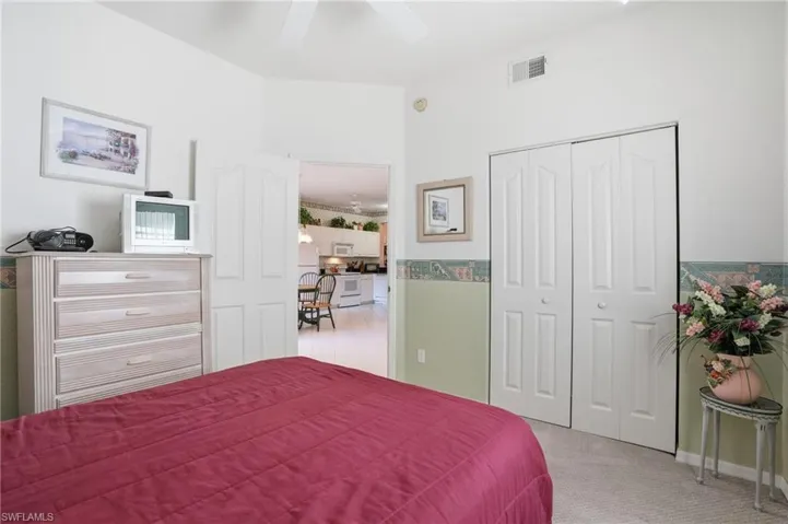 Bedroom featuring a closet, light colored carpet, and ceiling fan