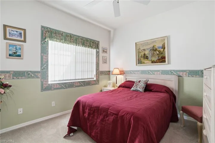 Carpeted bedroom with a ceiling fan and baseboards