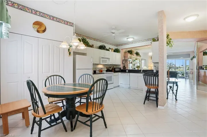 Dining space with ceiling fan and light tile patterned flooring