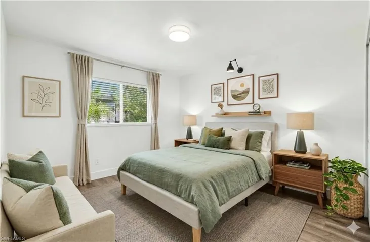 Bedroom 1 with wood finished floors and baseboards