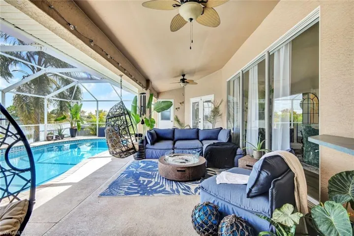 Sunroom featuring an outdoor living space with a fire pit, a swimming pool, a patio area, and ceiling fan