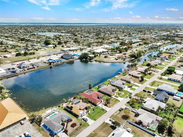 Aerial view of property and surrounding area with nearby suburban area and a nearby body of water