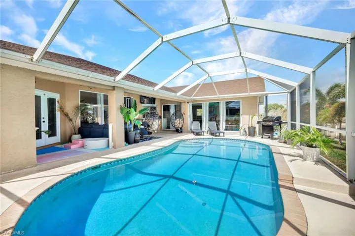 Outdoor pool with a patio, french doors, a sunroom, and a lanai