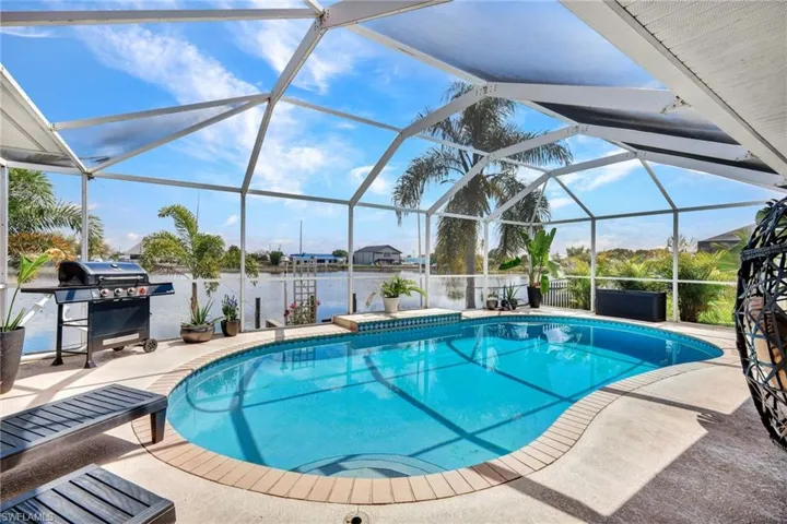 Swimming pool with area for grilling, a sunroom, a patio, and glass enclosure