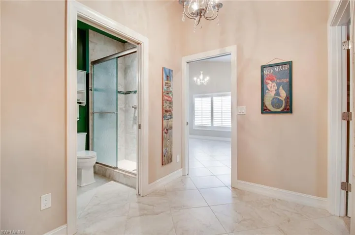 Corridor featuring a notable chandelier