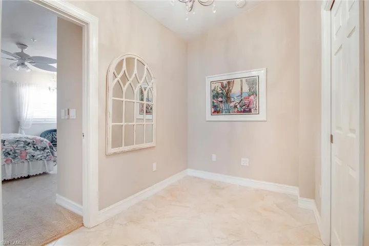 Empty room featuring ceiling fan with notable chandelier