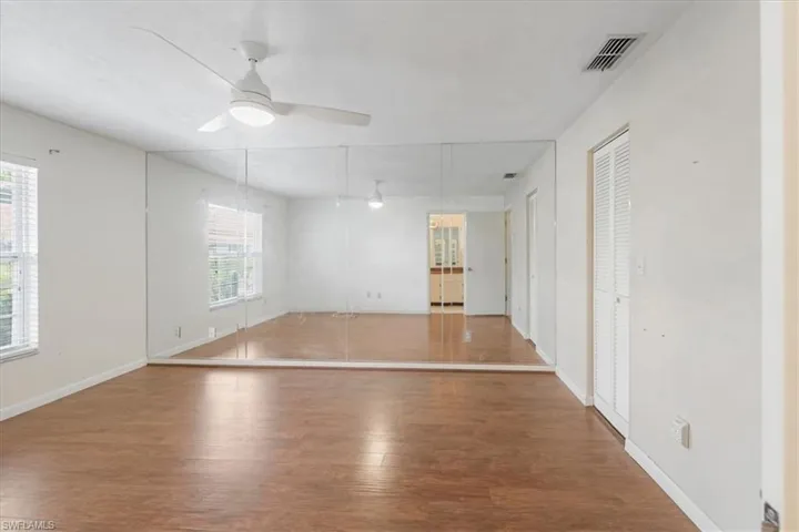 Unfurnished room with plenty of natural light, wood-type flooring, and ceiling fan
