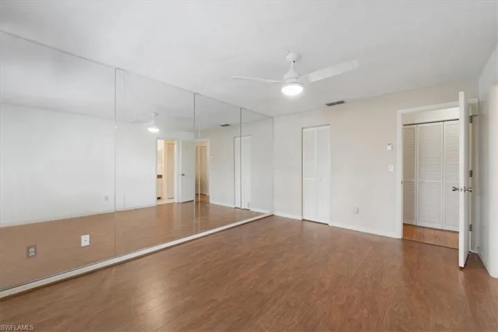 Unfurnished room featuring dark hardwood / wood-style floors and ceiling fan