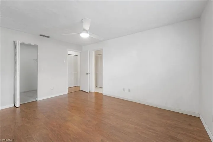 Unfurnished bedroom with ceiling fan and hardwood / wood-style floors