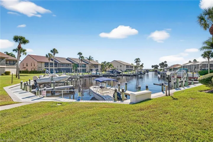 Dock featuring a yard, a residential view, boat lift, and a water view