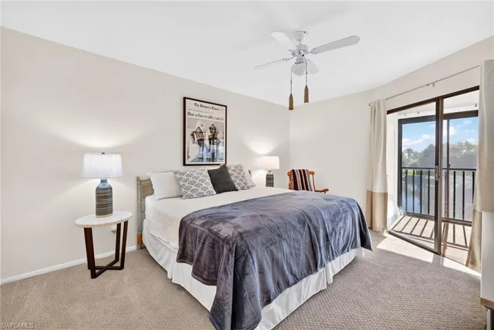 Bedroom with carpet, access to exterior, ceiling fan, and a water view